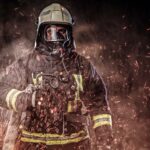 A firefighter dressed in a uniform in a studio.