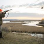 waterfowl-hunter-shooting-into-sky-during-duck-hunting-sunrise-hunting-banner